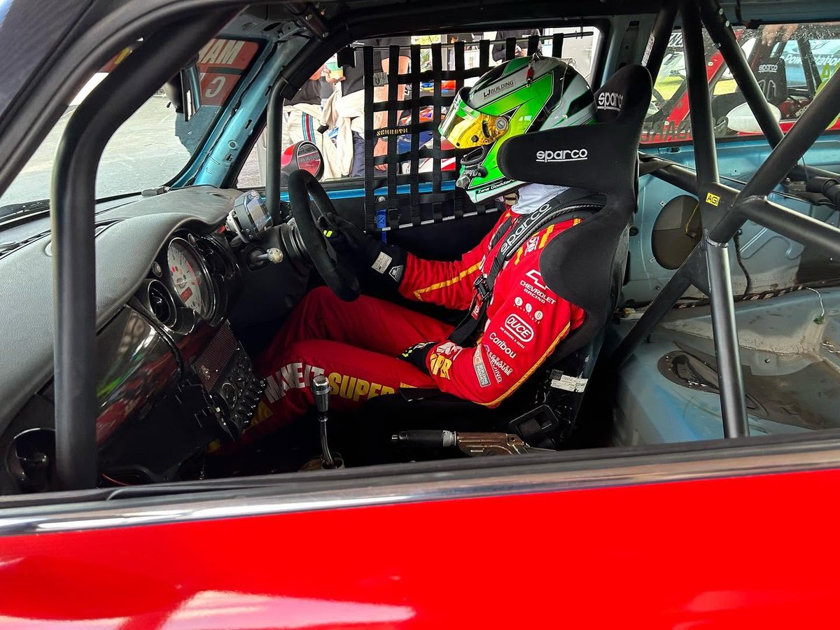 A SuperMini Challenge driver strapped into the cockpit, ready to race